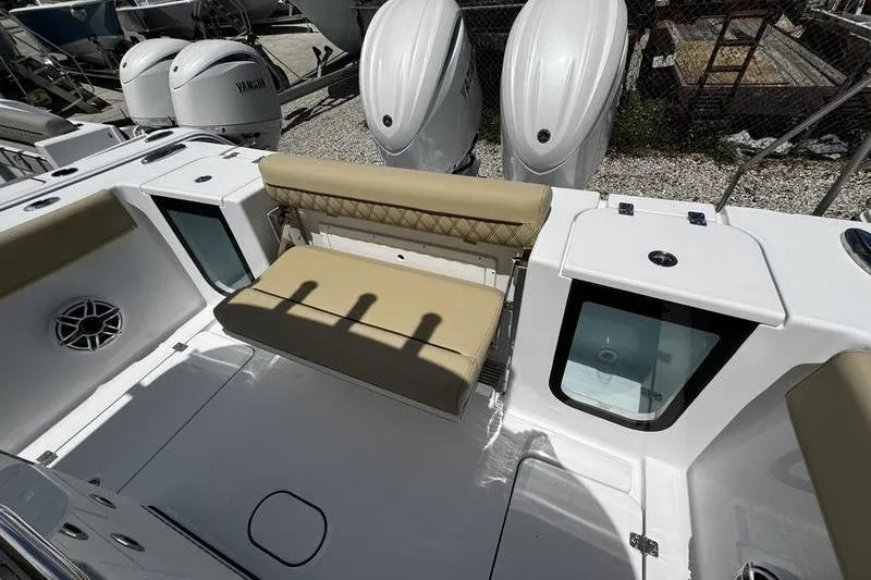 Slide: The Image of 2026 Sportsman Open 262 Center Console boat interior with beige seating and storage compartments. - 30