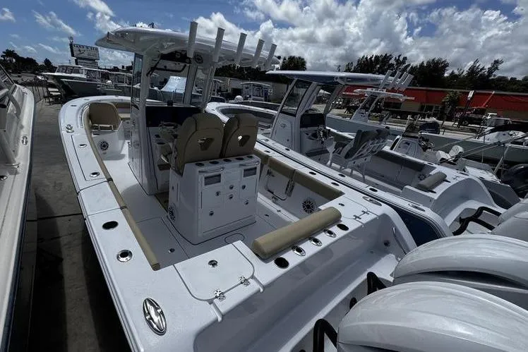 Slide: The Image of 2026 Sportsman Open 262 Center Console boat with dual engines, docked under a cloudy sky. - 4