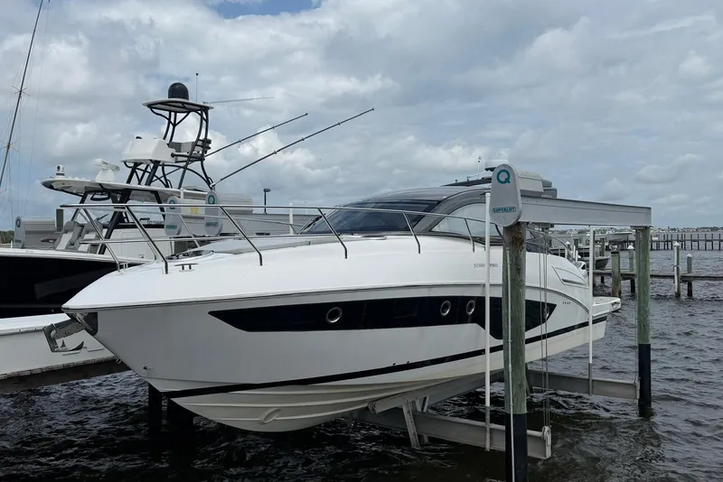 The Image of 2022 Schaefer 400 Sport yacht docked on a lift under cloudy skies. - 0