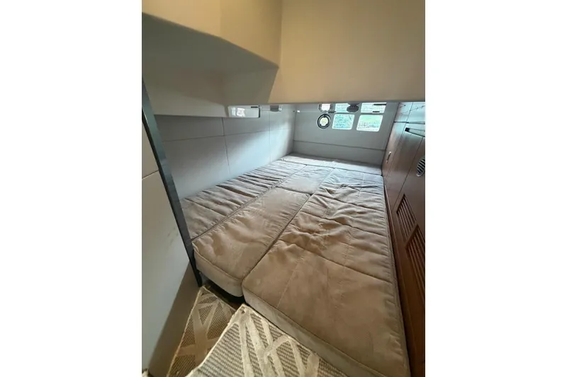 Slide: The Image of Interior cabin of 2022 Schaefer 400 Sport yacht with cozy bedding and porthole windows. - 18