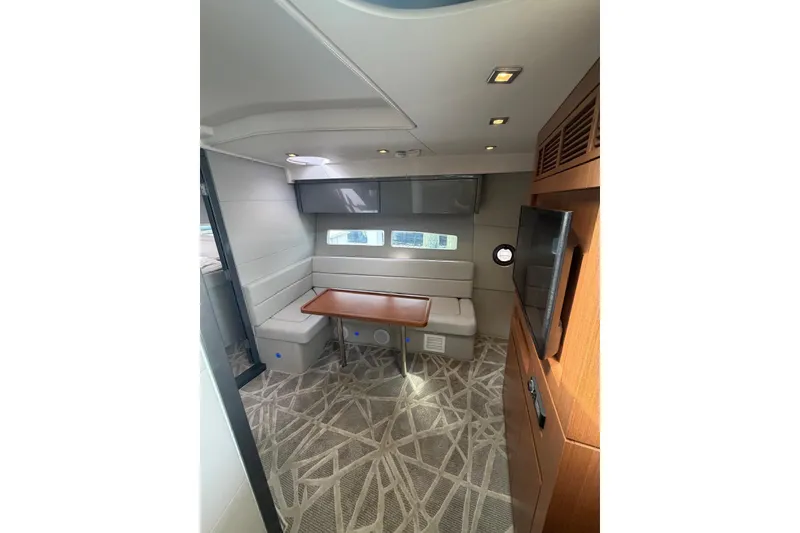 Slide: The Image of Interior of 2022 Schaefer 400 Sport yacht with modern seating and wooden table. - 21