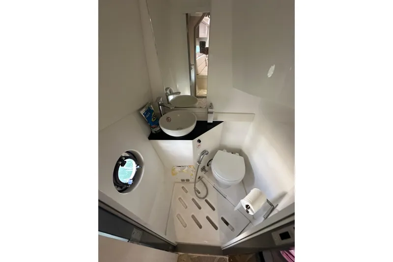 Slide: The Image of Compact bathroom in 2022 Schaefer 400 Sport yacht with modern fixtures and porthole window. - 7