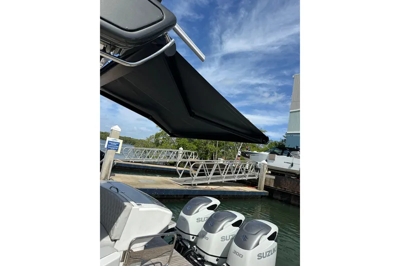 Slide: The Image of 2022 Schaefer 400 Sport boat with Suzuki engines docked under a sunny sky. - 9