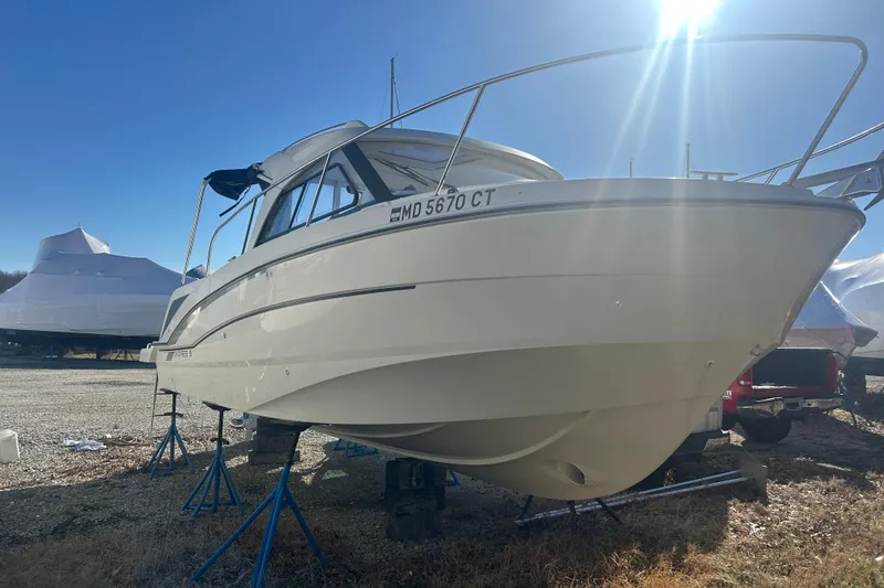 The Image of 2021 Beneteau Antares 8 boat on stands, sunlit, with clear blue sky background. - 0