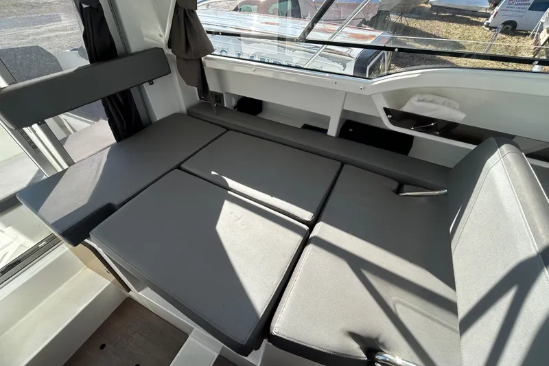 Slide: The Image of Interior seating area of 2021 Beneteau Antares 8 boat with gray cushions. - 11