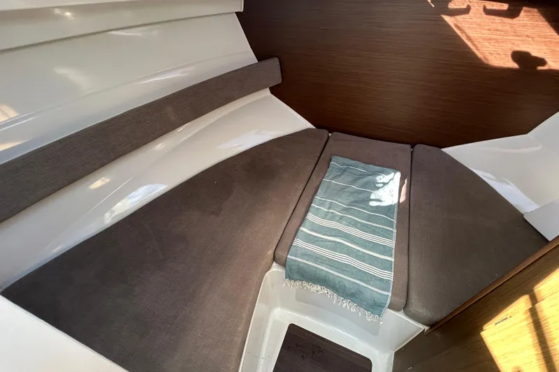 Slide: The Image of Interior cabin of 2021 Beneteau Antares 8 with cushioned seating and striped towel. - 13