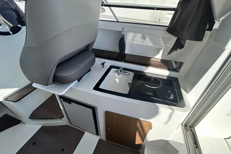 Slide: The Image of Interior of 2021 Beneteau Antares 8 featuring compact kitchenette with sink and stove. - 5