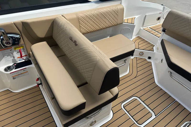 Slide: The Image of 2026 Sea Ray SDX 250 boat interior with beige seating and teak flooring. - 12
