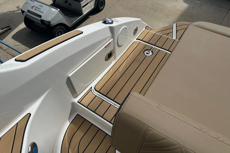 Slide: The Image of 2026 Sea Ray SDX 250 boat deck with tan seating and wood-style flooring. - 13