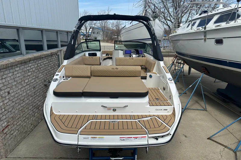 Slide: The Image of 2026 Sea Ray SDX 250 boat with tan seating, docked outdoors. - 2