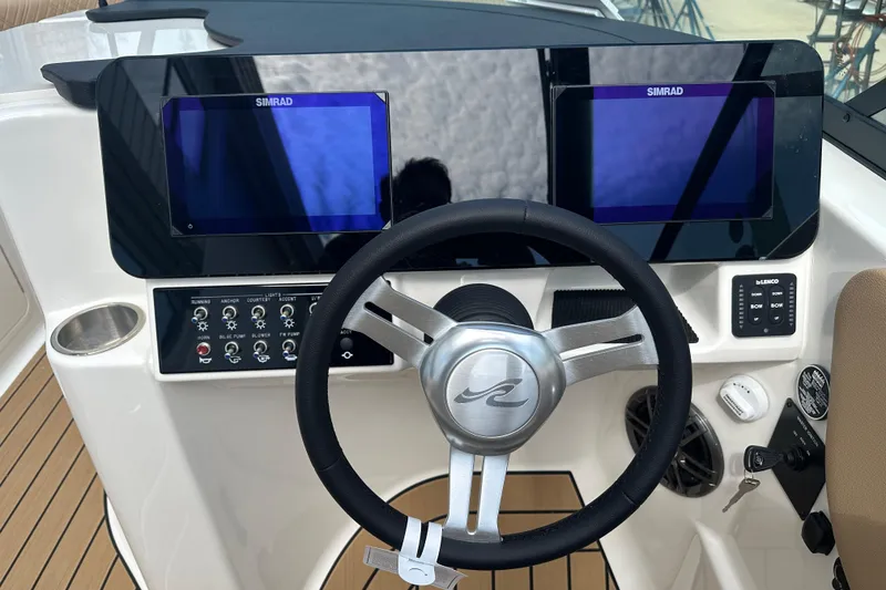 Slide: The Image of 2026 Sea Ray SDX 250 helm with dual Simrad displays and modern controls. - 7