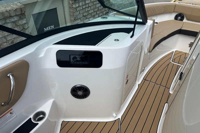 Slide: The Image of 2026 Sea Ray SDX 250 boat interior with tan seating and wood-style flooring. - 9