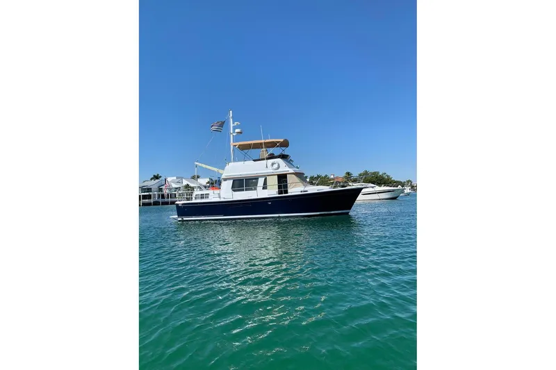 The Image of 1997 Sabreline 36 Express yacht on clear blue water, sunny day, coastal background. - 1