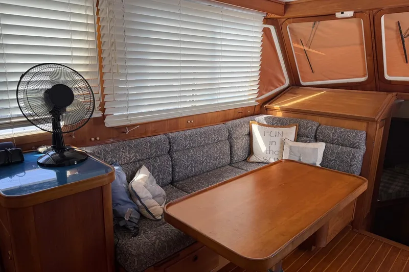 Slide: The Image of Cozy interior of 1997 Sabreline 36 Express with cushioned seating and wooden table. - 12