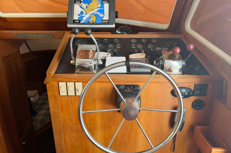 Slide: The Image of 1997 Sabreline 36 Express helm with steering wheel, navigation controls, and Garmin GPS display. - 13