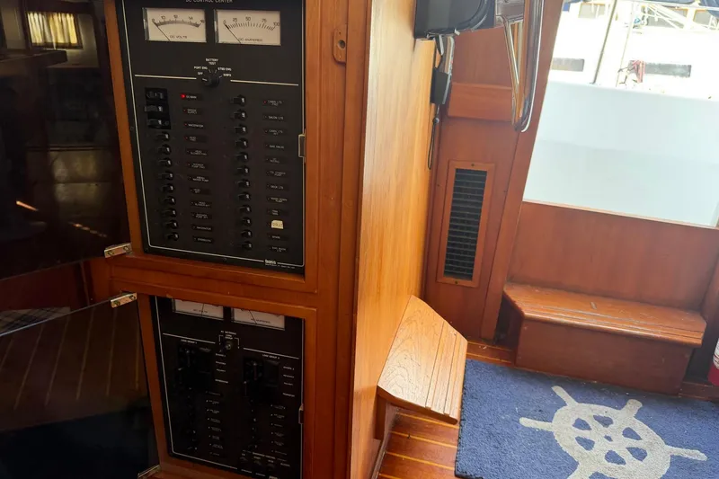 Slide: The Image of Electrical control panel inside 1997 Sabreline 36 Express boat, featuring wooden interior and nautical decor. - 21