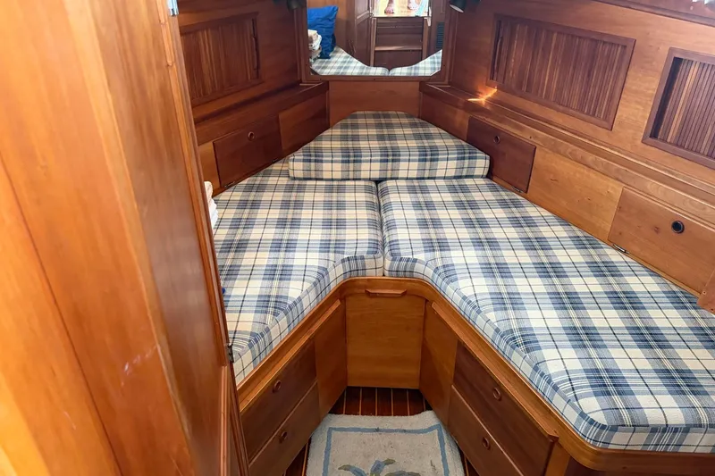 Slide: The Image of 1997 Sabreline 36 Express cabin with plaid bedding and wooden interior. - 8