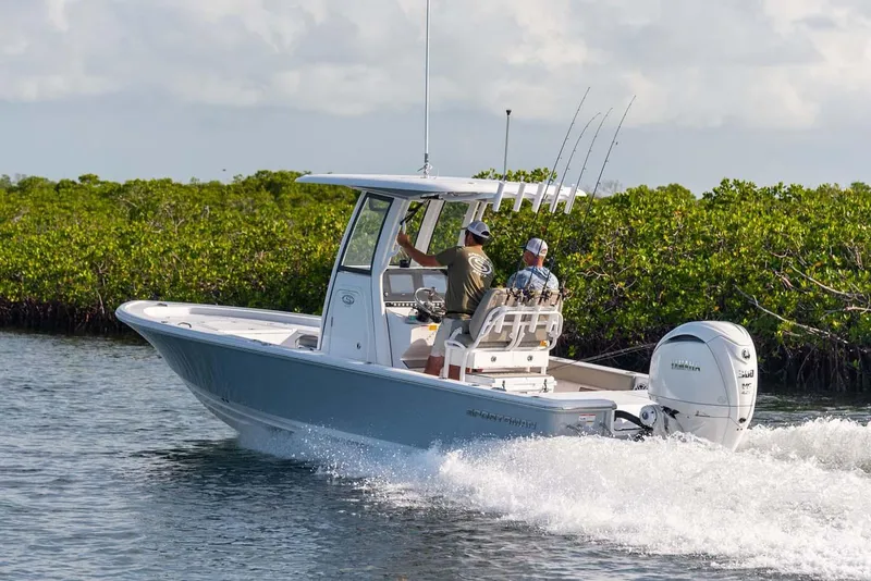 Slide: The Image of Manufacturer Provided Image: 2025 Sportsman Masters 247 Bay Boat cruising on water near lush greenery. - 3