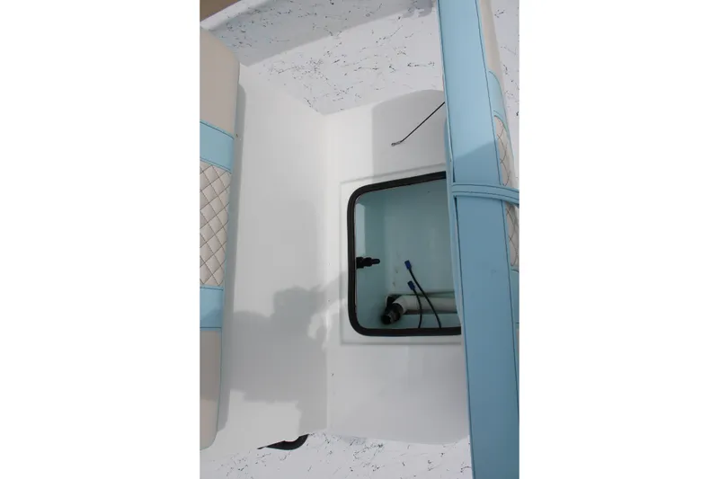 Slide: The Image of 2026 Freedom Boats 19 PATRIOT interior storage compartment with blue cushioned seating. - 21