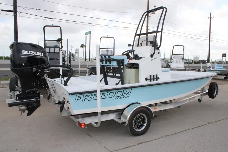 Slide: The Image of 2026 Freedom Boats 19 PATRIOT with Suzuki engine on trailer, parked outdoors. - 4