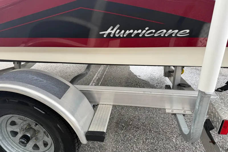 Slide: The Image of 2023 Hurricane SunDeck Sport 185 OB boat on trailer, showcasing sleek design and branding. - 6