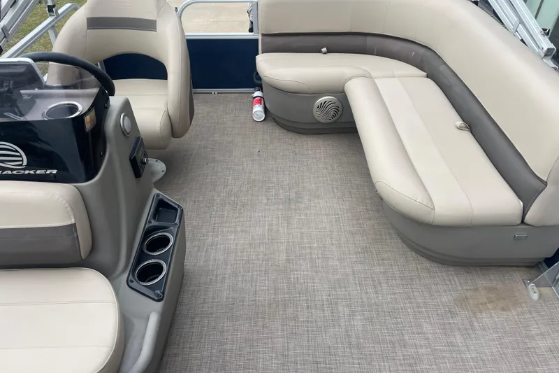 Slide: The Image of 2023 Sun Tracker Bass Buggy 16 XL Select interior with beige seating and steering console. - 2