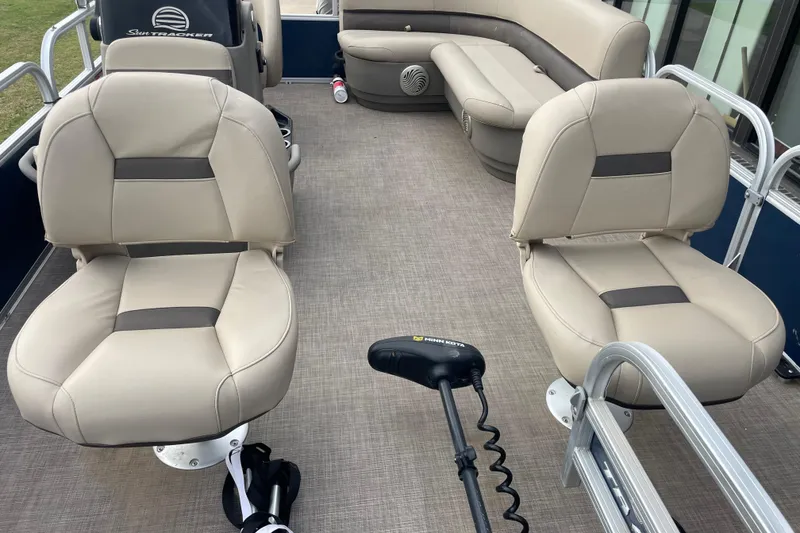 Slide: The Image of 2023 Sun Tracker Bass Buggy 16 XL Select interior with beige seating and Minn Kota trolling motor. - 4