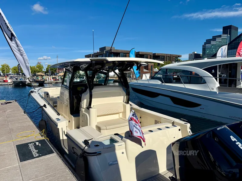 Slide: The Image of A Scout 330 LXF boat docked. It features a modern design and spacious cabin. - 33
