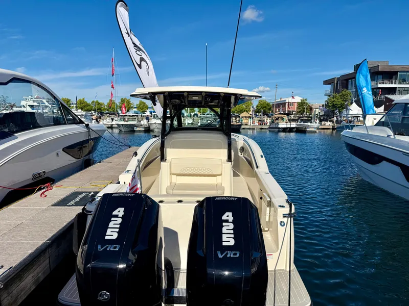 Slide: The Image of A 2027 Scout 330 LXF boat docked in sunny weather, featuring two powerful engines. - 2