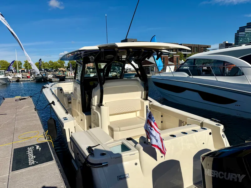 Slide: The Image of A 2027 Scout 330 LXF docked. It features a modern design and a flag. - 3