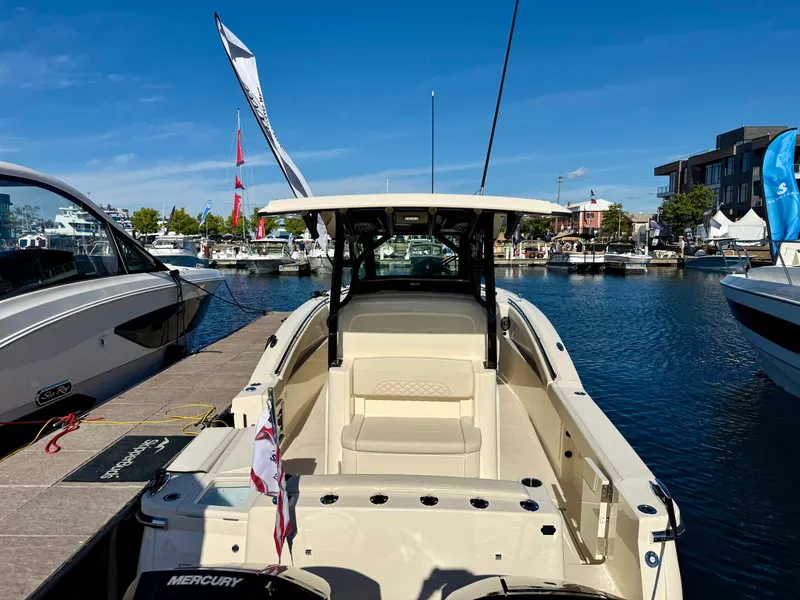 Slide: The Image of 2027 Scout 330 LXF at the dock, featuring a spacious deck and T-top. - 34