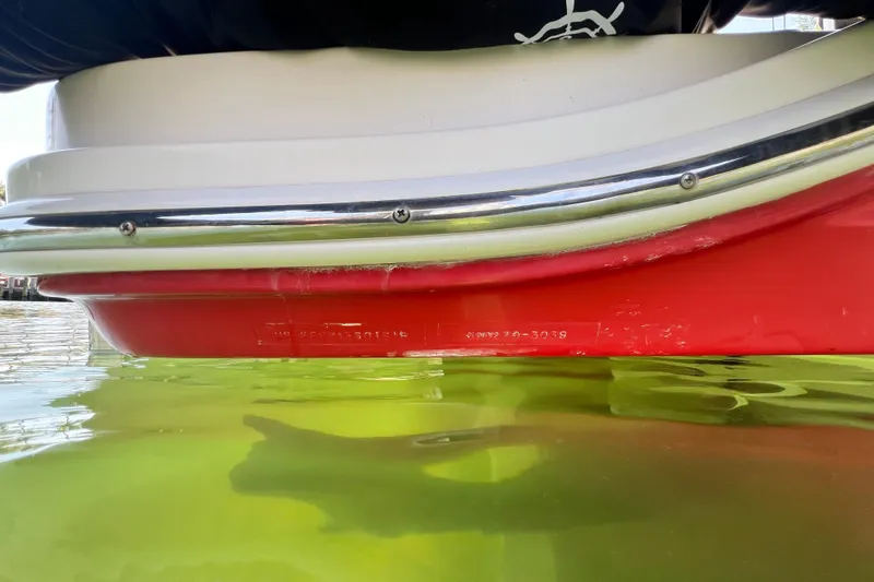 Slide: The Image of 2019 Sea Ray SDX 270 Outboard boat hull in water, showcasing red and white design. - 107