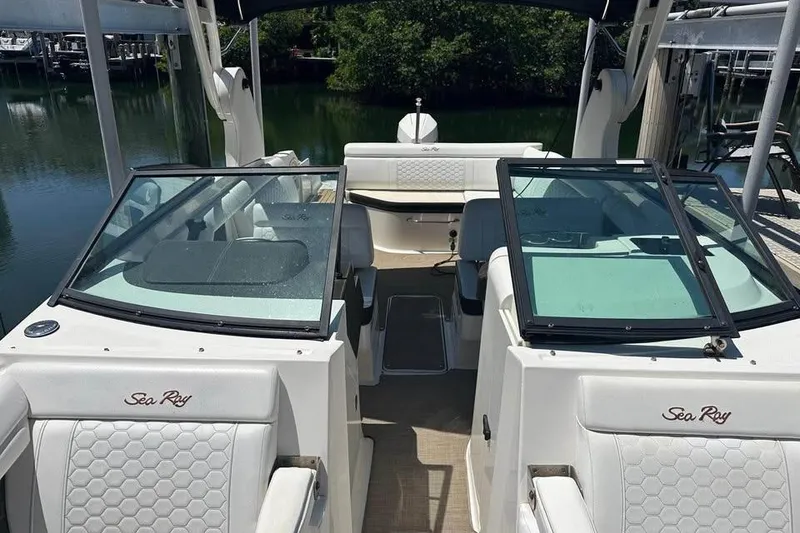 Slide: The Image of 2019 Sea Ray SDX 270 Outboard boat interior with white seating and glass windshields. - 3