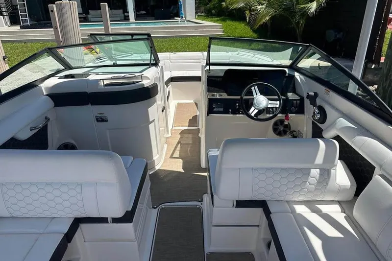 Slide: The Image of 2019 Sea Ray SDX 270 Outboard boat interior with white seating and modern dashboard. - 5