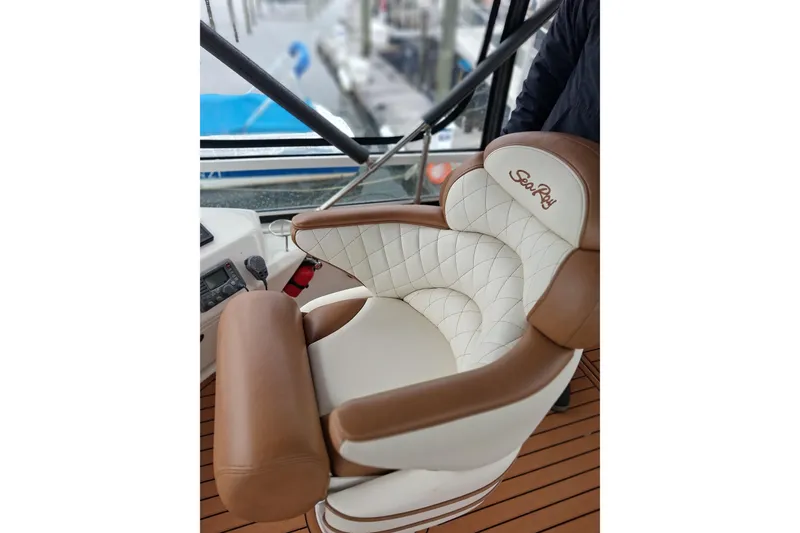 Slide: The Image of Luxurious captain's chair on 2003 Sea Ray 400 Sedan Bridge yacht, featuring elegant brown and white upholstery. - 13