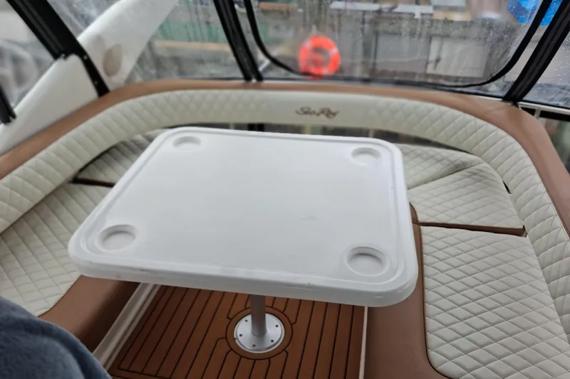 Slide: The Image of Interior seating area of a 2003 Sea Ray 400 Sedan Bridge with a white table. - 16
