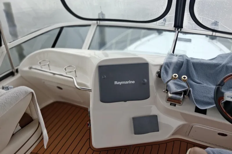 Slide: The Image of Helm of 2003 Sea Ray 400 Sedan Bridge with Raymarine navigation system and wooden flooring. - 18