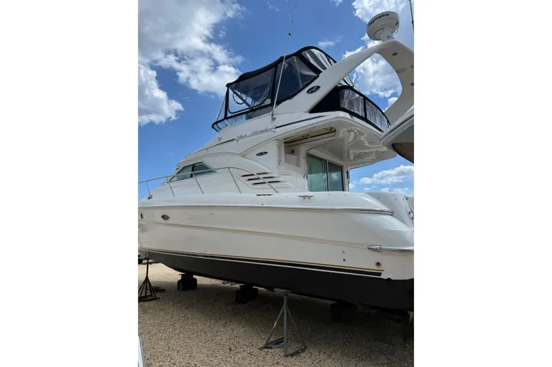 Slide: The Image of 2003 Sea Ray 400 Sedan Bridge yacht on stands under a blue sky. - 2