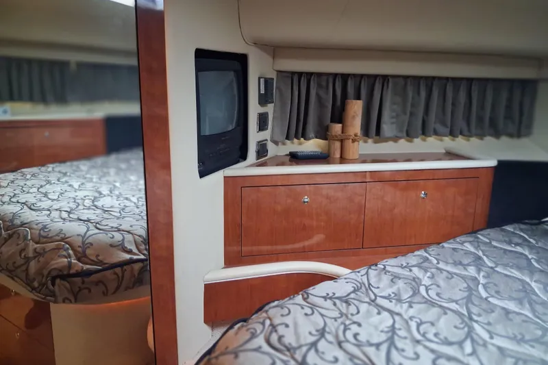 Slide: The Image of Luxurious interior of 2003 Sea Ray 400 Sedan Bridge with elegant wood cabinetry and patterned bedding. - 25