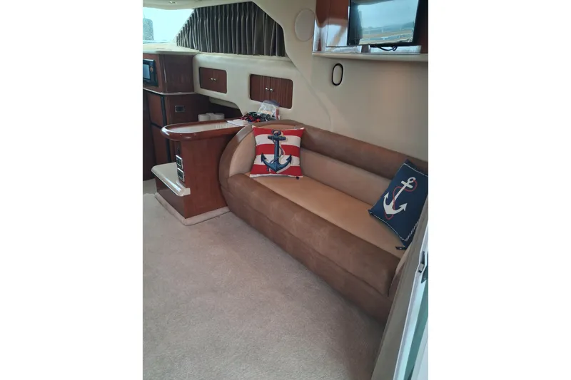 Slide: The Image of Interior of 2003 Sea Ray 400 Sedan Bridge with nautical-themed cushions on a brown sofa. - 27
