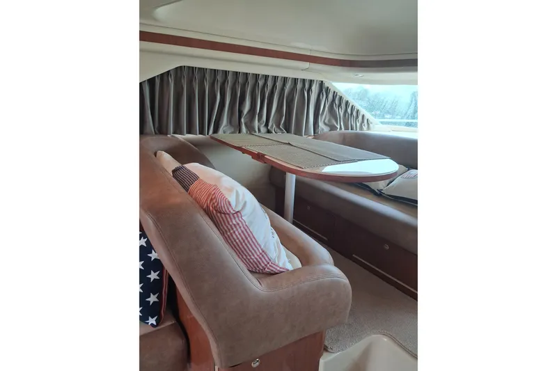 Slide: The Image of Interior of 2003 Sea Ray 400 Sedan Bridge with cozy seating and decorative pillows. - 28