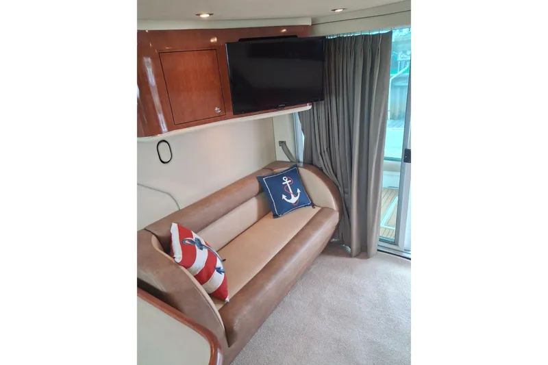 Slide: The Image of Interior of 2003 Sea Ray 400 Sedan Bridge with sofa, nautical pillows, and TV. - 32