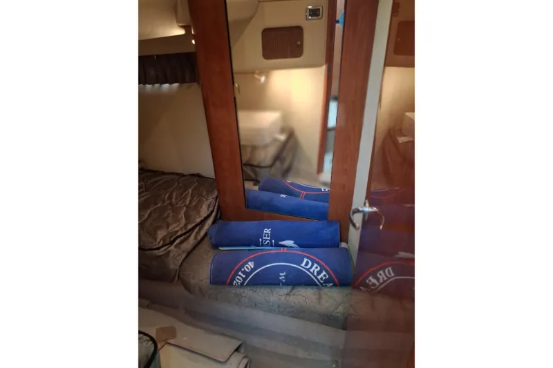 Slide: The Image of Interior cabin of 2003 Sea Ray 400 Sedan Bridge with blue towels and mirrored closet. - 34