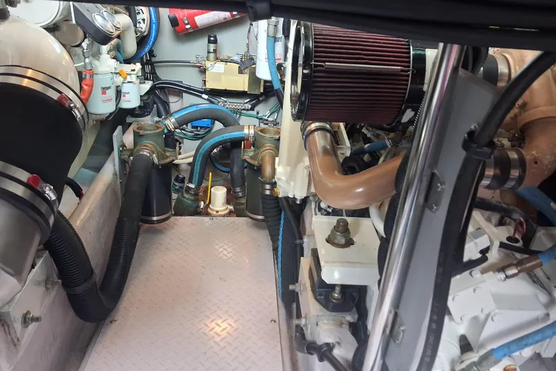 Slide: The Image of Engine room of a 2003 Sea Ray 400 Sedan Bridge with visible hoses and components. - 44