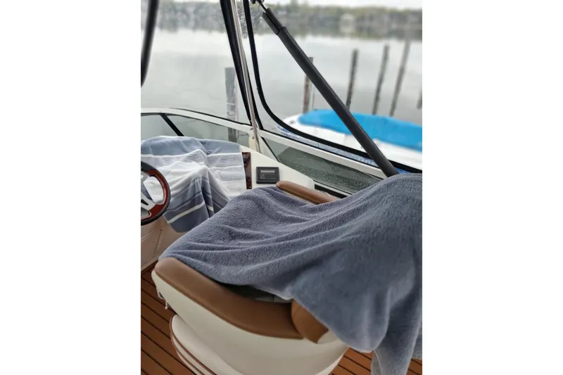 Slide: The Image of Interior view of 2003 Sea Ray 400 Sedan Bridge with covered seats and steering wheel. - 55