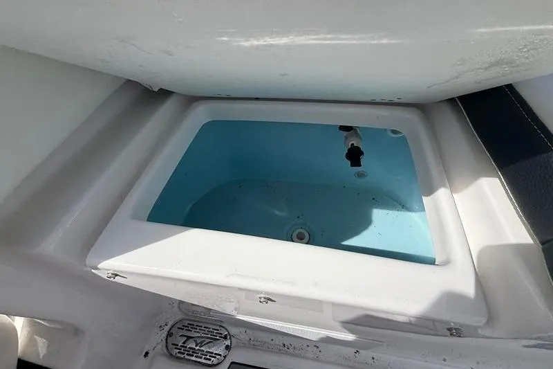 Slide: The Image of Livewell compartment on a 2022 Tidewater 272 LXF boat, featuring a blue interior. - 10