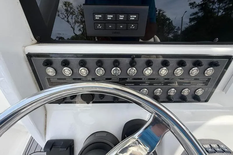 Slide: The Image of Control panel of a 2022 Tidewater 272 LXF boat with steering wheel and switches. - 19
