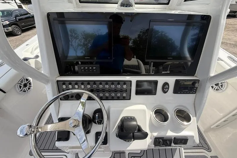 Slide: The Image of 2022 Tidewater 272 LXF boat dashboard with dual screens and steering wheel. - 20