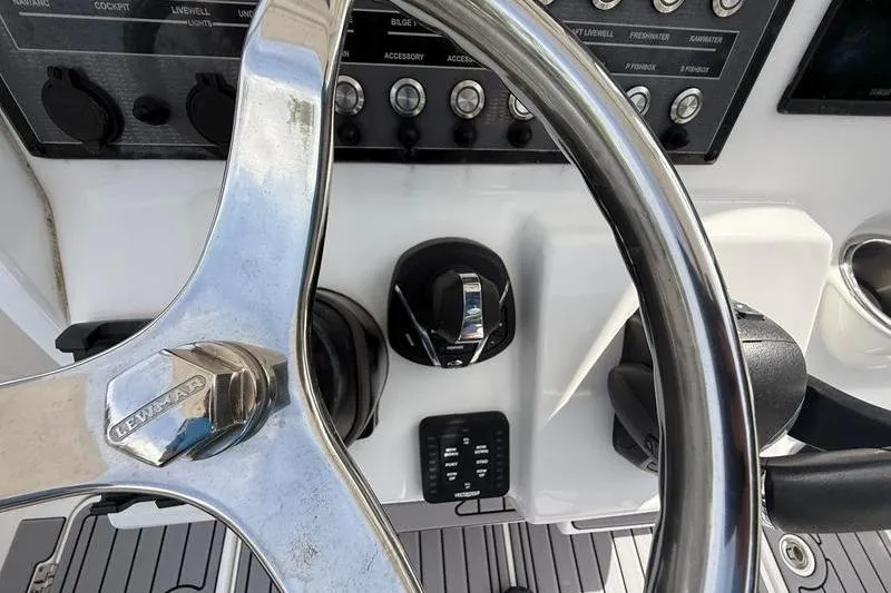 Slide: The Image of Close-up of 2022 Tidewater 272 LXF boat steering wheel and control panel. - 22