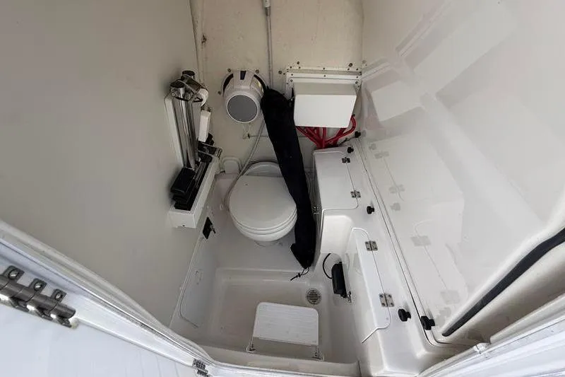 Slide: The Image of Interior of 2022 Tidewater 272 LXF boat bathroom with toilet and storage compartments. - 26